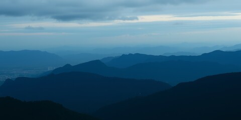 Obraz premium Silhouettes of mountains against a cloudy sky.