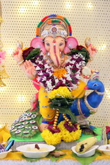 lord ganesha idol on Ganesh chaturthi. little Ganpati is sitting a beautiful peacock in the idol. the temple is decorated with lights and flowers. On the occasion on Ganesh Stapna on chaturthi 