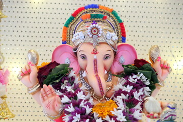 lord ganesha idol on Ganesh chaturthi. highlighted face of shree ganesha. closeup. the temple is decorated with lights and flowers. On the occasion on Ganesh Stapna on chaturthi 