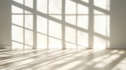 Fototapeta premium Sunlight Filtering Through Window Casting Shadows on White Wall and Wooden Floor.