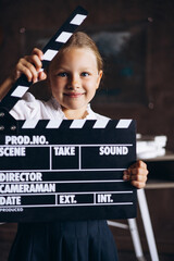 Schoolgirl holding film clapboard