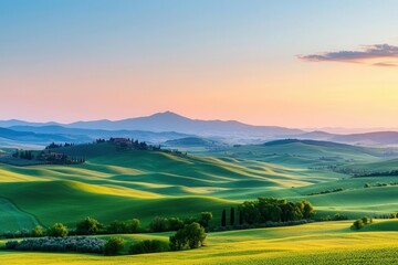 Obraz premium A wide shot of rolling hills and farmland at sunrise, with soft light illuminating the landscape