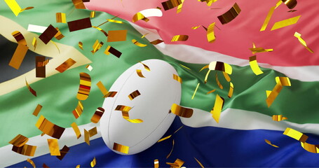 Image of confetti over white rugby ball and flag of south africa