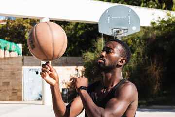 African american player spinning a ball on his finger on outdoor court