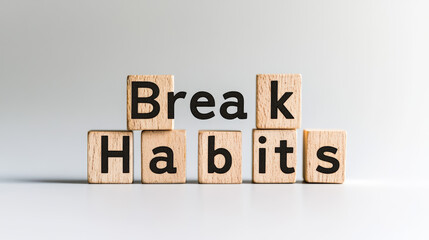 Wooden blocks spell out "Break Bad Habits" on a white background. This image represents overcoming negative habits and starting fresh. It's a message about self-improvement and healthy choices.