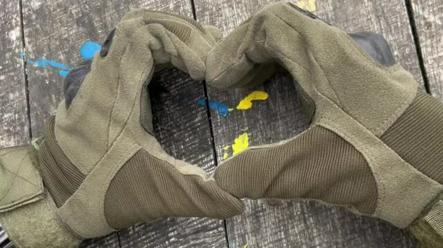 The Ukrainian soldier made a heart, Close up military man hold a heart of his own hands