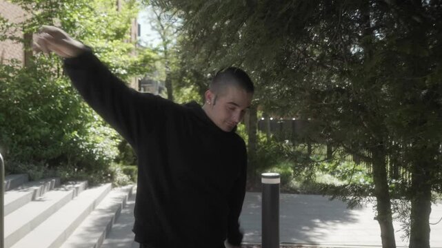 A young man in a hoodie dances freely along a sunny street, radiating positivity and good vibes. His carefree attitude, smooth moves, and confident style reflect joy, freedom, and self-expression.