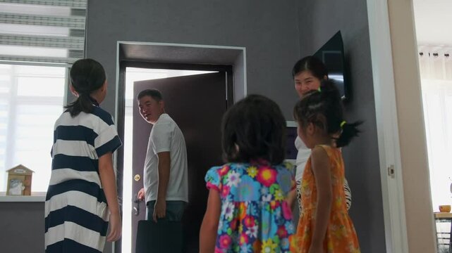 Family says goodbye to dad leaving for work, children and wife joyfully seeing him off at the door and waving their hands, low angle.