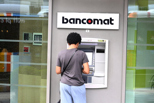 Luxembourg, Luxembourg - August 30, 2024: Woman near ATM of Raiffeisen bank in Luxembourg City.