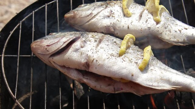 cuisson de deux poissons, dorades au barbecue	