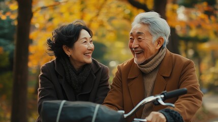 Senior japanese couple smiling and having fun riding bikes in autumn