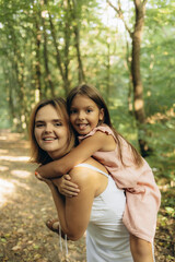 Fototapeta premium cheerful mother and daughter playing in the park