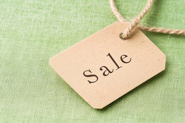 A tag with the word sale written on it on a green background