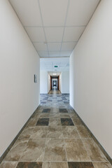 empty long corridor with red brick walls and doors in interior of modern apartments or office