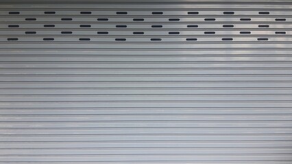 Rolling door. Steel shutter door of warehouse. The shutters are gray metal. Steel rolling shutter...