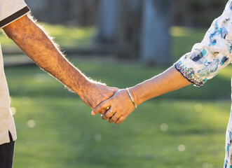 elderly couple holding hands together