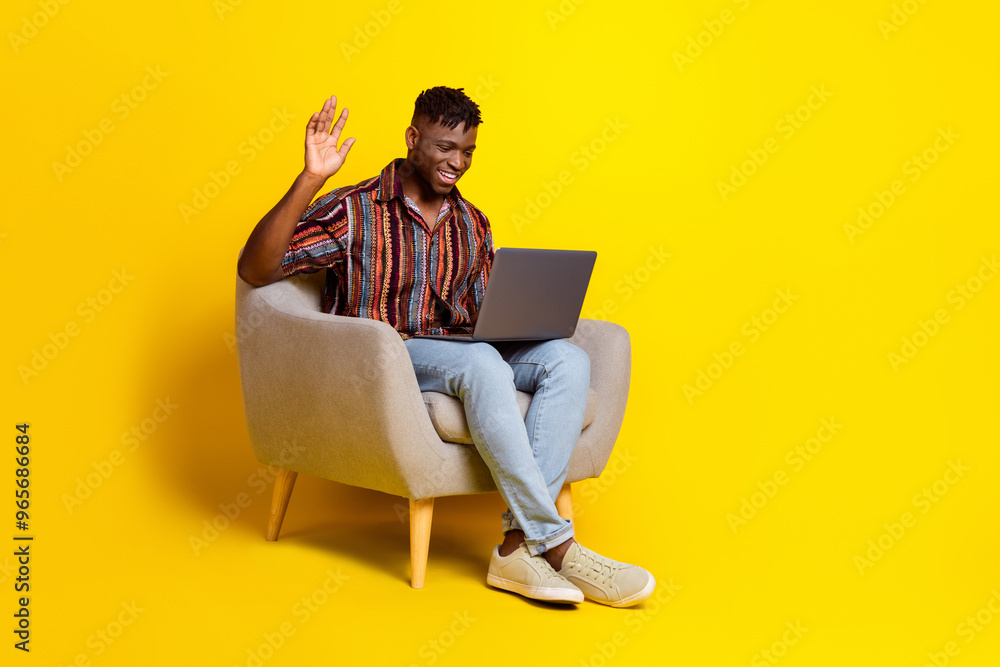 Wall mural full body portrait of nice young man sit chair video call laptop wear shirt isolated on yellow color