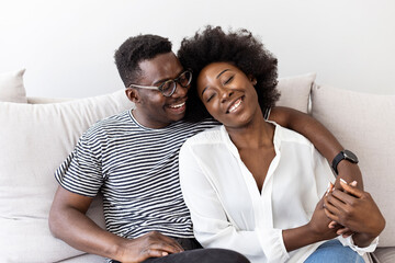 Happy Couple Embracing and Laughing on Comfortable Couch