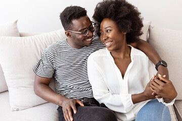 Happy Couple Laughing and Embracing on a Cozy Sofa