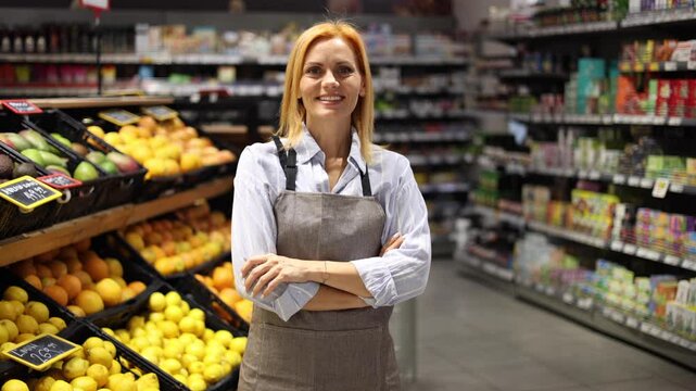 Saleswoman posing happily at the supermarket
