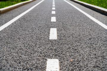 Obraz premium white lines on the asphalt close-up, road markings breaking line