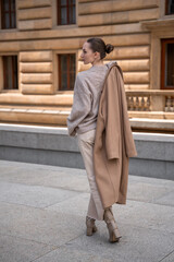 Young beautiful woman wearing coat walking in the city centre of Prague, Europe