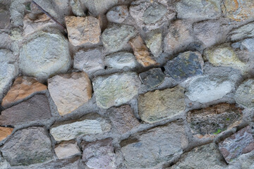 stone fence of uneven cobblestones gray and brown pattern