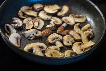 champignons mushrooms sliced fried in a pan sauce base