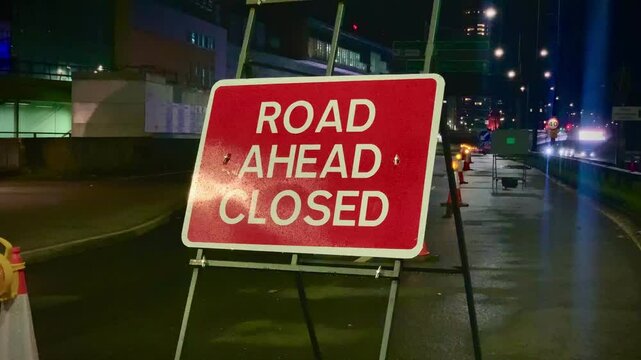 Red and White ROAD AHEAD CLOSED Road Sign at Night in Shepherd's Bush, West London England the United Kingdom Britain Europe