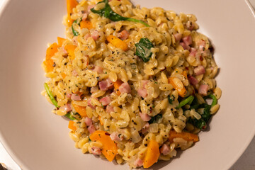 A bowl of risoni with vegetable and bacon.