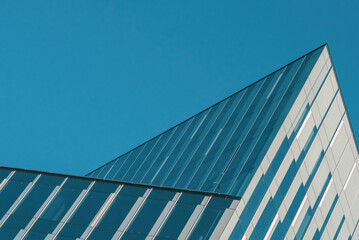 Obraz premium Fragments of modern buildings against the sky, capturing sleek lines, glass reflections, and bold architectural details, blending urban design with the open expanse of the horizon.