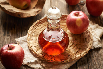 Apple cider vinegar in a glass jug with fresh apples