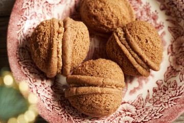 Traditional homemade Christmas cookies in the form of nuts filled with cream, close up