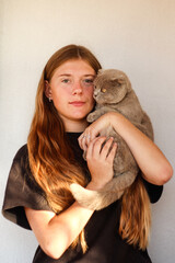 A heartwarming portrait of a girl hugging a Scottish Fold cat, showcasing their close friendship. gentle bond between the two. Vertical