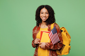 Young happy fun teen girl student wear brown yellow casual clothes backpack bag hold books American...