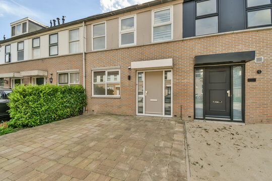 Suburban terraced houses with brick facade and parking space