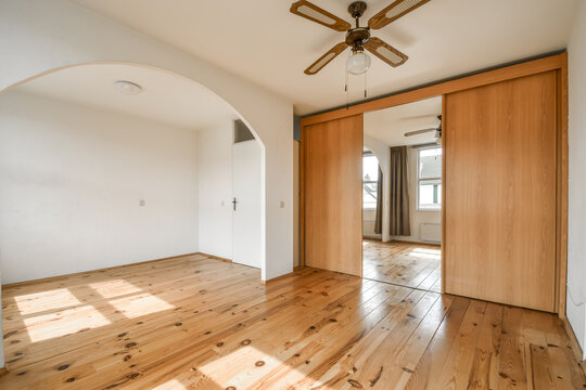 Spacious empty room with wooden features and ceiling fan
