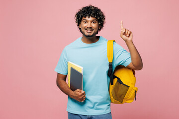 Young smart Indian boy student wear blue t-shirt casual clothes backpack bag hold books point index...