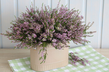 still life with a bouquet of heather on the table in the cottage. summer time, forest heather, a lush bouquet of flowering branches.