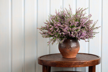 still life with a bouquet of heather on the table in the cottage. summer time, forest heather, a...