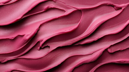 Close-up of smooth, flowing swirls of pink cream or paste, showcasing a textured surface with a glossy finish. Ideal for beauty, skincare, or cosmetic product design.