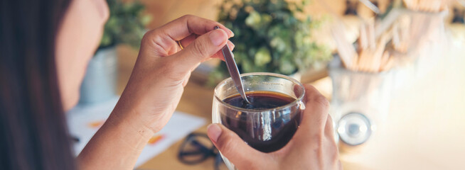 Banner hands of woman sitting office desk holding sweet coffee cup relax and enjoy with happy time. Panorama Hot coffee mug. Woman holding coffee cup relaxing after work at office in cafe copy space