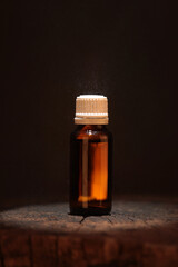 Amber glass bottle with white cap on dark background