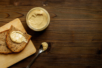 Jar of coconut butter cream and multigrain bread. Sugar and lactose free breakfast
