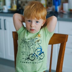 little child with red hair posing with serious look