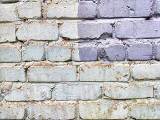 A weathered brick wall displays a mix of muted colors and textures, creating an interesting backdrop for text or artwork