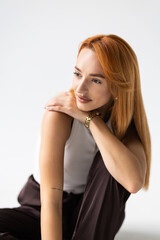 Obraz premium Happy young woman sitting on the floor on white background