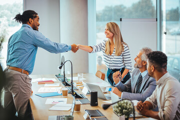 Obraz premium Diverse Team Celebrating Success with a Handshake in Office