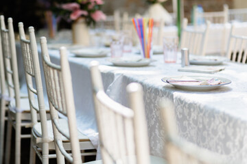 Elegant dining setup for a special occasion with white tables and colorful decorations in a garden setting