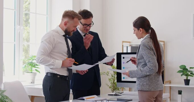 Office day, serious young supervisor analyses financial report, responsible worker paying attention on mistakes propose correction. Professional agent discussing paper document, data, terms conditions